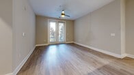 Located at 1000 Central Ave in Charlotte's vibrant 28204 corridor, this two-bedroom, two-bathroom residence offers a well-designed single-level layout finished with contemporary details throughout. Hardwood-style flooring runs continuously through the living areas and bedrooms, complemented by neutral wall tones that create a clean, cohesive aesthetic.

The open kitchen is a standout feature, equipped with sleek white cabinetry extending to the ceiling, granite countertops, a subway tile backsplash, stainless steel appliances, and a peninsula with an integrated sink — ideal for both everyday cooking and entertaining. Track and pendant lighting add a modern touch overhead.

The living area is bathed in natural light, highlighted by elegant French doors that open to an outdoor view, along with a ceiling fan for added comfort. The primary bedroom offers a generous footprint with dual windows that invite ample daylight. The second bedroom similarly benefits from natural light through well-positioned windows.

Both bathrooms are finished with white subway tile — one featuring a glass-enclosed walk-in shower with brushed nickel fixtures, and the other a full soaking tub with shower combination. A hallway connects the private quarters, which also includes two closets for storage. The unit is further equipped with an in-unit laundry connection.