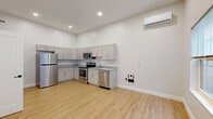 Located at 501 State St in Schenectady, NY, this thoughtfully designed one-bedroom, one-bathroom unit offers a clean, modern aesthetic throughout its efficiently organized floor plan. The open living and kitchen area is bright and airy, benefiting from impressively tall ceilings and recessed lighting that enhance the sense of space. A wall-mounted mini-split unit provides climate control for year-round comfort.

The kitchen is well-appointed with gray shaker-style cabinetry, granite-look countertops, and a full suite of stainless steel appliances including a refrigerator, electric range, built-in microwave, and dishwasher. Light wood-look luxury vinyl plank flooring runs consistently throughout the living spaces, adding warmth and continuity.

The bedroom is a comfortable and functional room, featuring a large window that allows natural light to fill the space, a dedicated wall-mounted mini-split, and direct access to a spacious walk-in closet outfitted with wire shelving and hanging rods for ample storage.

The bathroom is finished with neutral large-format tile flooring and includes a toilet and a full soaking tub with shower. Clean white walls throughout the unit create a bright, move-in-ready atmosphere ideal for a variety of living arrangements.
