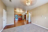 Located at 860 S 68th St in West Des Moines, Iowa, this single-floor unit offers a functional and well-appointed layout designed for comfortable everyday living. The open-concept living and kitchen area serves as the heart of the home, where warm beige walls and a ceiling fan complement the combination of plush carpet in the living space and durable hardwood-style flooring that extends into the kitchen. The kitchen is well-equipped with rich wood cabinetry, granite-style countertops, and a full suite of stainless steel appliances including a refrigerator, electric range, microwave, and dishwasher, all illuminated by track lighting overhead. A dedicated bedroom offers carpeted flooring, a window with natural light, and a clean, neutral palette. The bathroom features tile flooring, a wood-toned vanity, and a straightforward, practical design. A closeted laundry area conveniently houses a full-size side-by-side washer and dryer. The unit also includes an attached single-car garage with an automatic opener, providing secure parking and additional storage. Throughout the space, the consistent warm tones and practical finishes create a cohesive and inviting atmosphere.