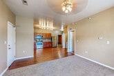 Located at 860 S 68th St in West Des Moines, Iowa, this single-floor unit offers a functional and well-appointed layout designed for comfortable everyday living. The open-concept living and kitchen area serves as the heart of the home, where warm beige walls and a ceiling fan complement the combination of plush carpet in the living space and durable hardwood-style flooring that extends into the kitchen. The kitchen is well-equipped with rich wood cabinetry, granite-style countertops, and a full suite of stainless steel appliances including a refrigerator, electric range, microwave, and dishwasher, all illuminated by track lighting overhead. A dedicated bedroom offers carpeted flooring, a window with natural light, and a clean, neutral palette. The bathroom features tile flooring, a wood-toned vanity, and a straightforward, practical design. A closeted laundry area conveniently houses a full-size side-by-side washer and dryer. The unit also includes an attached single-car garage with an automatic opener, providing secure parking and additional storage. Throughout the space, the consistent warm tones and practical finishes create a cohesive and inviting atmosphere.