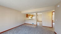 Located at 140 S Kendall Ave in Kalamazoo, Michigan, this three-story property offers seven bedrooms and four bathrooms across a well-distributed floor plan. The main level features a welcoming entrance that opens into a carpeted living room bathed in natural light from large windows fitted with vertical blinds. The open-concept kitchen is equipped with warm wood cabinetry, a peninsula with a built-in sink, and white appliances, flowing naturally into the living and dining areas. Neutral-toned walls and warm wood baseboards carry consistently throughout the home, creating a cohesive aesthetic. The bedrooms are generously proportioned, with soft carpeting, vertical-blind windows, and ample closet storage — including sliding-door closets and built-in shelving units in select rooms. Some bedrooms feature hard-surface flooring, adding variety across the levels. The four bathrooms are cleanly finished with wood-toned vanities, large mirrors with overhead lighting, and combination tub/shower units set on wood-look tile flooring. Staircases connect each of the three floors, which are each similarly sized and consistently laid out. The overall ambiance is clean, neutral, and functional, making this property well-suited for accommodating multiple occupants.