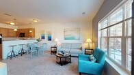 This single-floor residence offers a thoughtfully designed layout that balances comfort and functionality across its key living spaces. The open living and dining area is welcoming and bright, featuring plush carpeting, a large picture window that frames outdoor views, and a bold accent wall that adds depth and contrast. The space comfortably accommodates a full seating arrangement alongside a dining set, creating a natural flow between relaxation and entertaining.

The kitchen is efficiently designed with warm wood cabinetry, granite-style countertops, a double-basin sink, and a full suite of black appliances including a refrigerator, range, and built-in microwave. Light hardwood flooring adds a clean, polished look to this functional workspace.

Two carpeted bedrooms provide comfortable retreats, each with natural light from well-placed windows and ceiling fans for added comfort. The primary bedroom offers generous proportions, while the secondary bedroom is cozily sized with a warm, restful ambiance.

A dedicated den or office space is particularly notable, featuring three windows on two walls that flood the room with natural light — ideal for a home office or flexible-use room.

The full bathroom is finished with tile flooring, warm wood vanity cabinetry, a large mirror, and a full tub-shower combination, completing this well-rounded and move-in-ready residence.
