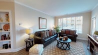 This single-floor residence on Warrick Trail offers a thoughtfully designed layout that balances comfort and functionality throughout. The living room serves as the heart of the home, featuring crown molding, neutral walls, and large windows with slatted blinds that invite an abundance of natural light and views of the surrounding neighborhood. The space flows seamlessly into a dedicated dining area, defined by an elegant arched entryway, hardwood-style flooring, and a pendant light overhead — ideal for everyday meals and entertaining alike. The kitchen is outfitted with rich dark cabinetry, granite countertops, a white subway tile backsplash, and a full suite of stainless steel appliances, including a refrigerator, range, microwave, and dishwasher. Two well-proportioned bedrooms are finished with plush carpeting, ceiling fans, and windows that provide natural light. Both bathrooms feature dark wood vanities with granite countertops and hardwood-style flooring; one includes a full tub-shower combination. Crown molding and consistent finishes throughout the home contribute to a cohesive, polished aesthetic that is both warm and refined.