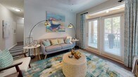 Located at 100 Eighty Oak Ave in Mount Pleasant, South Carolina, this single-floor residence offers a well-designed layout with thoughtful finishes throughout. A welcoming hallway with wood-style flooring and a striped runner guides residents into the main living areas.

The galley-style kitchen is a standout feature, outfitted with white shaker cabinetry, quartz countertops, a classic subway tile backsplash, and stainless steel appliances. A dedicated laundry room with a full-size washer and dryer is conveniently accessible directly from the kitchen.

The dining area accommodates comfortable gatherings beneath a pendant light fixture, with neutral walls providing a versatile backdrop. A dedicated home office nook with a window offers a functional workspace flooded with natural light.

The primary bedroom is generously sized, featuring plush carpet, multiple windows that invite natural light, a ceiling fan, and direct access to an en-suite bathroom. An additional bedroom also features carpet flooring and a large window. Bathrooms are finished with white cabinetry, quartz-style countertops, and wood-style tile flooring. The overall palette of soft neutrals and clean white trim creates a bright, cohesive ambiance throughout the home.