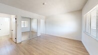 Located at 11635 Downey Avenue in Downey, California, this single-floor unit offers a thoughtfully arranged layout comprising a living room, kitchen, closet, and bathroom. The space is finished with light wood-look flooring that runs throughout, complementing the bright white walls and creating a clean, cohesive aesthetic.

The living room is an open, airy area bathed in natural light from large windows fitted with horizontal blinds, offering views of the surrounding neighborhood. The textured ceiling adds a subtle architectural detail to the room.

The kitchen is efficiently designed with white shaker-style cabinetry — both upper and lower — featuring black hardware accents. A stainless steel gas range and a single-basin stainless steel sink with a brushed nickel faucet are set against white countertops, delivering a modern and functional cooking space.

The closet area is equipped with mirrored sliding doors, enhancing the sense of space and adding a practical reflective element to the interior.

The bathroom maintains the home's clean, modern character with white walls, wood-look tile flooring, a white vanity with a framed mirror, and a window that invites natural light. A vanity light fixture provides additional illumination, completing this well-appointed space.