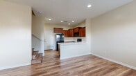 Located in Glendale, Arizona, this two-story home offers a thoughtfully organized layout spread across two levels. The ground floor houses the kitchen and living area, garage, and supporting utility spaces, while the upper level contains the bedrooms, bathrooms, and additional closets. The kitchen is well-appointed with rich walnut-toned cabinetry, light quartz-style countertops, black appliances including a range, microwave, refrigerator, and dishwasher, all set atop durable wood-look plank flooring. The bedrooms are carpeted and feature ceiling fans and natural light from windows with outdoor views of surrounding greenery. The primary bedroom offers a generous footprint with dual windows. Bathrooms are finished with wood-look flooring and include a full tub-shower combination with built-in shelving and wood-accented vanity cabinetry. A dedicated laundry room houses a full-size washer and dryer with overhead shelving for storage. The attached garage is clean and spacious with a smooth sealed concrete floor, automatic opener, electrical panel, and a water heater, providing ample utility and vehicle storage. With three closets and a hallway connecting the upper level, this home balances practical function with comfortable living throughout.