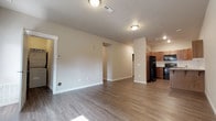 Located at 514 East Hastings Road in Spokane, Washington, this single-floor unit offers a thoughtfully designed layout with a clean, modern aesthetic throughout. The open-concept living area is finished with durable wood-look flooring and neutral-toned walls, creating a bright and versatile space that flows seamlessly toward the kitchen and dining areas. Natural light filters in through the windows, enhancing the unit's welcoming atmosphere.

The kitchen is well-appointed with warm wood cabinetry, white tile backsplash, light countertops, and a full suite of black appliances including a refrigerator, electric range, over-the-range microwave, and dishwasher. A stainless steel sink completes the functional workspace.

Two bathrooms serve the unit — one featuring a walk-in shower with built-in shelving and a wood-toned vanity, and a second with a full soaking tub and shower combo alongside a matching vanity with ample counter space. Both bathrooms continue the wood-look flooring found throughout the main living areas.

The bedrooms are carpeted for comfort and include closet storage. A dedicated utility area houses a stacked Whirlpool washer and dryer alongside a water heater, providing convenient in-unit laundry. The overall design balances practicality with modern finishes throughout.