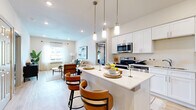 This single-story residence in Lacy-Lakeview, TX offers a thoughtfully designed open-concept layout that seamlessly connects the kitchen, dining, and living areas. The modern kitchen is a standout feature, showcasing crisp white shaker cabinetry, stainless steel appliances including a range and built-in microwave, a full-size refrigerator, and a white quartz peninsula with seating for two — illuminated by stylish pendant lighting. The living area is bright and welcoming, filled with natural light from large windows and finished with light wood-tone flooring that carries throughout the entire unit. The spacious primary bedroom features a tray ceiling, generous windows with blinds and curtains, and a ceiling fan. It is complemented by a dedicated closet with built-in shelving and an adjacent bathroom with white vanity cabinetry. A flexible office space provides natural light through a large window and is accessed via a hallway with panel doors. Three full bathrooms ensure ample convenience. Additional storage is available through a walk-in closet with dual hanging rods. The overall aesthetic is clean, contemporary, and cohesive, with neutral tones and modern finishes creating a bright and functional living environment.