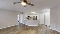 Located at 4545 Sunny Brook Way in Winter Springs, Florida, this single-story, two-bedroom, two-bathroom residence offers a thoughtfully organized layout across a comfortable footprint. The open-concept living and kitchen area forms the heart of the home, where wood-look plank flooring flows seamlessly throughout. The kitchen is equipped with stainless steel appliances, including a refrigerator, range, and microwave, complemented by crisp white cabinetry, a light-toned countertop peninsula, and an undermount sink. A ceiling fan with integrated lighting serves the living area, while natural light enters through multiple windows dressed with white horizontal blinds.

The dining area benefits from additional windows on two walls, creating a bright corner setting with a pendant light fixture overhead. Both bedrooms feature the same wood-look flooring, neutral wall tones, and generous closet space, with the primary bedroom including a walk-in closet with built-in shelving. Each bathroom includes a full tub-shower combination with a curved curtain rod and a vanity with white countertops. A dedicated utility room and two closets round out the functional layout of this clean, move-in-ready home.