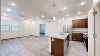Located at 1515 S Yale St in Flagstaff, Arizona, this 2-bedroom, 2-bathroom single-floor residence offers a thoughtfully designed layout with modern finishes throughout. The open-concept kitchen and living area serves as the heart of the home, featuring a central island with a granite-look countertop, an undermount sink, and elegant pendant lighting. Rich dark wood cabinetry pairs with a full suite of stainless steel appliances, including a refrigerator, range, and microwave. A wall-mounted mini-split unit provides efficient climate control, and a built-in pantry offers additional storage just off the kitchen. Light wood-look plank flooring runs consistently throughout the entire residence, contributing to a bright, cohesive aesthetic. Both bedrooms are comfortably sized and filled with natural light from large windows with blinds. The primary bedroom is generously proportioned and connects to a well-equipped en-suite bathroom featuring dual sinks with granite-look countertops, dark wood vanity cabinetry, and a soaking tub. The second bathroom mirrors the same quality finishes with a single vanity and a tub-shower combination. Each bedroom is served by a dedicated walk-in closet, and a utility room and hallway round out the functional layout of this clean, move-in ready residence.