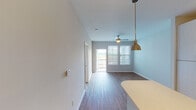 Located at 1095 Manhattan Blvd in Dayton, Kentucky, this single-floor residence offers a thoughtfully designed layout with a clean, contemporary aesthetic throughout. The kitchen serves as a standout feature, showcasing white cabinetry with sleek hardware, a classic subway tile backsplash, light quartz countertops, a large island, and a full suite of stainless steel appliances including a refrigerator, range, microwave, and dishwasher. Warm wood-look flooring runs through the kitchen and living areas, complemented by track lighting and a stylish pendant light over the island.

The living and dining area flows naturally toward a glass door that opens to a private balcony, framing outdoor views and allowing natural light to fill the space. A ceiling fan adds comfort overhead. Bedrooms are finished with neutral carpet and feature windows fitted with blinds, providing both brightness and privacy. The bathroom includes a soaking tub and shower combination with full tile surround and a curved curtain rod. A dedicated laundry area houses a full-sized GE washer and dryer with overhead wire shelving, adding practical convenience to this well-appointed space.