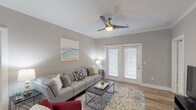 This single-floor residence offers two bedrooms and two full bathrooms within a well-designed layout that balances comfort and functionality. The living room features crown molding, light hardwood-style flooring, a ceiling fan, and French doors that invite natural light and provide outdoor access, creating an open and airy atmosphere.

Adjacent to the living area, the dining room continues the hardwood-style flooring and is accented by crown molding and a stylish orb pendant light fixture, making it an elegant space for entertaining. The kitchen is equipped with white shaker-style cabinetry, light countertops, and stainless steel appliances, offering ample storage and a clean, modern aesthetic.

Both bedrooms are generously sized, featuring plush carpeting, multiple windows for natural light, ceiling fans, and walk-in or reach-in closet space. The two full bathrooms are finished with striking marble-style tile flooring, white vanities with clean countertops, and tub-shower combinations, lending a crisp, polished look. Neutral gray tones carried throughout the residence create a cohesive and contemporary ambiance.