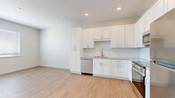 Located at 920 Manatee Ave W in Bradenton, Florida, this efficiently designed one-bedroom, one-bathroom unit offers a clean, contemporary aesthetic throughout its single floor. Light wood-style flooring runs continuously through the main living areas, creating a bright and cohesive feel. The open-concept layout seamlessly connects the living area to the kitchen, which serves as a standout feature of the space. The kitchen is outfitted with white shaker-style cabinetry, granite-look countertops, a subway tile backsplash, and a full suite of stainless steel appliances including a refrigerator, range, over-the-range microwave, and dishwasher. Recessed lighting illuminates the kitchen area effectively. The bedroom offers a comfortable footprint with a ceiling fan, a window fitted with blinds for natural light and privacy, and access to a dedicated closet with louvered bifold doors. The bathroom features marble-look tile flooring, a tub-shower combination with coordinating wall tile, a vanity with granite-look countertop, and a large mirror. A stacked washer and dryer unit is conveniently housed in a closeted hallway nook. Neutral wall tones and consistent finishes throughout give the space a clean, move-in-ready appearance.