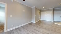 Located at 119 Cornerstone St in Lynchburg, Virginia, this well-appointed single-floor residence offers a thoughtfully designed layout comprising one bedroom, one bathroom, a kitchen, a bonus room, and two closets. The open-concept living and kitchen area is anchored by light-toned hardwood-style flooring, crown molding, recessed lighting, and a ceiling fan, creating a bright and welcoming atmosphere. French doors at the rear of the living space introduce natural light and provide outdoor access. The kitchen is a standout feature, boasting rich dark wood cabinetry, granite countertops, a subway tile backsplash, a central island with pendant lighting, and a full suite of stainless steel appliances including a refrigerator, range, microwave, and dishwasher. The spacious primary bedroom offers plush carpeting, a ceiling fan, a double-door closet, and direct access to the full bathroom. The bathroom is finished with large-format tile flooring, a dark wood vanity, and a tub/shower combination. The bonus room, also carpeted and ceiling fan-equipped, offers flexibility as a home office or additional living space. Neutral gray tones throughout give the space a clean, modern feel.