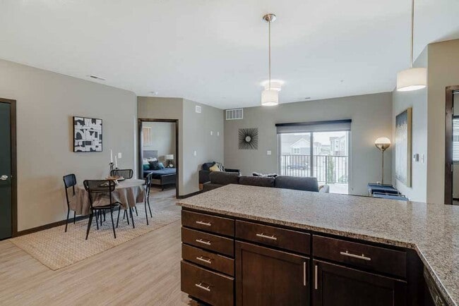 Entertaining is made easy in the 2-bed Magnolia featuring a large peninsula granite countertop. - WH Flats