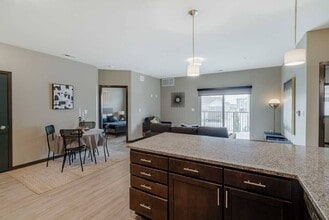 Entertaining is made easy in the 2-bed Magnolia featuring a large peninsula granite countertop. - WH Flats