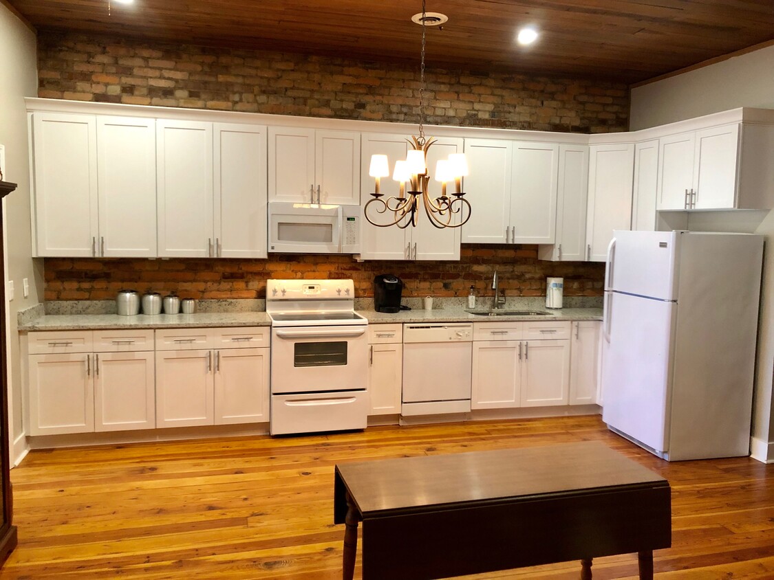 Huge kitchen with granite counter tops and exposed brick - 105 B W Main St