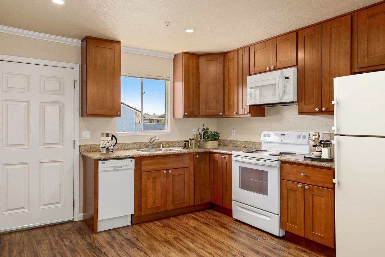 Open concept kitchen with solid wood cabinets and granite countertops. - The Palms Apartments