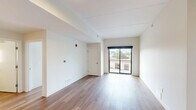 Located at 1359 Plainfield Ave NE in Grand Rapids, Michigan, this well-appointed 2-bedroom, 1-bathroom unit offers a clean, modern aesthetic across a single thoughtfully designed floor. Warm-toned hardwood flooring runs throughout the entire space, creating a cohesive and inviting atmosphere.

The kitchen is a functional highlight, featuring light maple cabinetry, granite countertops, a stainless steel refrigerator, dishwasher, range, and microwave. Track lighting illuminates the workspace, and the open layout allows a clear sightline into the adjoining living areas.

Both bedrooms are bright and well-proportioned, each featuring double-door closets for generous storage. Large, black-framed windows flood the rooms with natural light and offer views of the surrounding neighborhood's mature trees and streetscape. The primary bedroom includes a sliding glass door leading to a private balcony.

The bathroom is clean and modern, with a walk-in shower, granite-topped vanity with maple cabinetry, a window for natural light, and hardwood flooring that ties seamlessly to the rest of the unit.

Overall, the space presents a minimalist, contemporary design with neutral tones, quality finishes, and an efficient layout suited to comfortable everyday living.