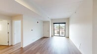 Located at 1359 Plainfield Ave NE in Grand Rapids, Michigan, this well-appointed 2-bedroom, 1-bathroom unit offers a clean, modern aesthetic across a single thoughtfully designed floor. Warm-toned hardwood flooring runs throughout the entire space, creating a cohesive and inviting atmosphere.

The kitchen is a functional highlight, featuring light maple cabinetry, granite countertops, a stainless steel refrigerator, dishwasher, range, and microwave. Track lighting illuminates the workspace, and the open layout allows a clear sightline into the adjoining living areas.

Both bedrooms are bright and well-proportioned, each featuring double-door closets for generous storage. Large, black-framed windows flood the rooms with natural light and offer views of the surrounding neighborhood's mature trees and streetscape. The primary bedroom includes a sliding glass door leading to a private balcony.

The bathroom is clean and modern, with a walk-in shower, granite-topped vanity with maple cabinetry, a window for natural light, and hardwood flooring that ties seamlessly to the rest of the unit.

Overall, the space presents a minimalist, contemporary design with neutral tones, quality finishes, and an efficient layout suited to comfortable everyday living.