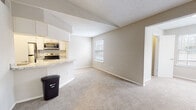 Located at 5620 Wood Run Blvd in Henrico, Virginia, this single-floor residence offers a well-organized layout with a clean, neutral aesthetic throughout. The open-concept living and dining area features plush carpeting and connects seamlessly to the kitchen, which is outfitted with white cabinetry, a granite-topped peninsula, stainless steel appliances including a range, microwave, and refrigerator, and wood-look flooring that adds warmth to the space. A tiled backsplash and an integrated sink complete the functional kitchen design.

The bedrooms are generously sized, each finished with soft carpeting, neutral wall tones, and white-trimmed windows fitted with blinds that allow for natural light while maintaining privacy. The primary bedroom benefits from multiple windows, offering views of surrounding greenery. A dedicated laundry area with side-by-side washer and dryer hookups provides added convenience.

Two full bathrooms serve the residence, each featuring granite-topped vanities with white cabinetry, wood-look flooring, and a full soaking tub with shower combination. The textured ceilings and clean white trim throughout lend a consistent, well-maintained character to the entire space, making it a practical and comfortable home in a residential Henrico neighborhood.