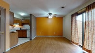 Located at 687 Carroll St in Akron, Ohio, this two-floor home offers a practical and functional layout across multiple rooms. The entryway features tile flooring that transitions into warm wood-look hardwood flooring carried throughout the main living areas and bedrooms, creating a cohesive aesthetic.

The main living area is open and inviting, highlighted by a bold accent wall painted in a warm amber tone and a ceiling fan with integrated lighting. Large windows dressed with curtain panels allow natural light to fill the space, lending an airy feel. The living area flows directly into the kitchen, which is equipped with oak cabinetry, dark countertops, a tile backsplash, and white appliances including a range, dishwasher, and refrigerator. The kitchen features tile flooring and ample cabinet storage overhead.

The bedrooms are comfortably sized, each featuring wood-look flooring, windows with exterior views, and dedicated closets with shelving for organized storage. The home includes two bathrooms: one with a tub-shower combination and tile flooring, and another with a glass-enclosed stand-up shower and vinyl flooring, providing convenience across both floors.