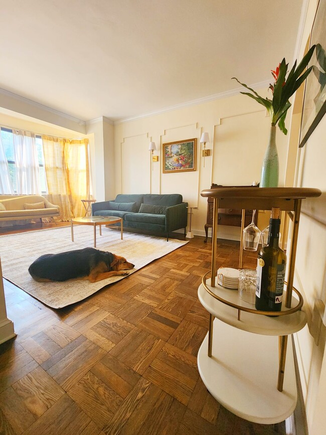 Sun soaked living room w/ sweeping bay windows and tasteful mid-century furnishings! - 2515 K St NW