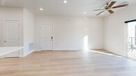 Located at 983 W State St in Hurricane, Utah, this 2-bedroom, 1-bathroom unit offers a thoughtfully designed single-level layout with a clean, contemporary aesthetic throughout. The open-concept living, dining, and kitchen area serves as the heart of the home, featuring light-toned hardwood-style flooring, recessed lighting, and a ceiling fan. The kitchen stands out with rich walnut-toned cabinetry, a sweeping white quartz peninsula with an undermount sink, stainless steel appliances including a range, microwave, and refrigerator, and pendant lighting overhead. A pantry provides additional storage convenience. The living area extends to a private balcony, filling the space with natural light. Both bedrooms are carpeted and well-lit, with the primary bedroom offering generous proportions and access to a walk-in closet with built-in shelving and hanging rods. Additional closets provide ample storage throughout. The bathroom features a full tub-shower combination with clean white tile surround and continues the light hardwood-style flooring. A dedicated laundry area and hallway complete the efficient floor plan, making this a well-appointed and move-in-ready space.