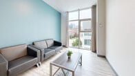 Located at 133 University Ave W in Waterloo, Ontario, this 2-bedroom, 1-bathroom unit offers a thoughtfully designed layout across a single floor. Light wood-style flooring runs throughout, creating a clean, cohesive aesthetic.

The living room is bright and welcoming, featuring a striking accent wall in soft teal and floor-to-ceiling windows that frame views of the surrounding Waterloo cityscape, filling the space with natural light.

The kitchen is well-equipped and functional, showcasing taupe shaker-style cabinetry, a marble-look tile backsplash, granite countertops, and a central island that provides additional prep and dining space. Stainless steel appliances, including a refrigerator and range, complete the kitchen.

The primary bedroom is a comfortable size, fitted with large windows overlooking the urban surroundings and built-in closet storage. The second bedroom is bright and versatile, also benefiting from large windows and light-toned walls.

The bathroom is clean and practical, featuring a stand-up shower, vanity with under-cabinet storage, and neutral tile flooring. A hallway connects the rooms efficiently, maximizing the use of the overall footprint. This unit is ideally situated near the University of Waterloo.