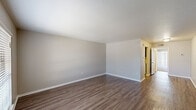 This one-bedroom, one-bathroom unit in Baton Rouge, Louisiana, offers a practical and well-organized single-floor layout. The living area features wood-style laminate flooring and neutral gray walls, creating a clean, understated aesthetic. A sliding glass door with vertical blinds allows natural light to filter in, lending the space an open feel. A hallway connects the main living spaces, providing a logical flow throughout the unit.

The kitchen is equipped with dark espresso cabinetry, light granite-patterned countertops, a double stainless steel sink, and a matching backsplash. White appliances, including a refrigerator and range, complement the space efficiently. Wood-style flooring continues through the kitchen, maintaining a cohesive look.

The bedroom is generously sized and features plush carpeting, a window with blinds for natural light, and dual reach-in closets with bifold doors, offering ample storage. Neutral wall tones keep the room calm and versatile.

The bathroom includes a white tile tub-and-shower combination, a toilet, and a vanity with dark cabinetry, a marble-patterned countertop, and an integrated sink. Wood-style flooring ties the bathroom's design together. Overall, the unit presents a functional and cohesive living environment.