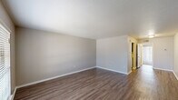 This one-bedroom, one-bathroom unit in Baton Rouge, Louisiana, offers a practical and well-organized single-floor layout. The living area features wood-style laminate flooring and neutral gray walls, creating a clean, understated aesthetic. A sliding glass door with vertical blinds allows natural light to filter in, lending the space an open feel. A hallway connects the main living spaces, providing a logical flow throughout the unit.

The kitchen is equipped with dark espresso cabinetry, light granite-patterned countertops, a double stainless steel sink, and a matching backsplash. White appliances, including a refrigerator and range, complement the space efficiently. Wood-style flooring continues through the kitchen, maintaining a cohesive look.

The bedroom is generously sized and features plush carpeting, a window with blinds for natural light, and dual reach-in closets with bifold doors, offering ample storage. Neutral wall tones keep the room calm and versatile.

The bathroom includes a white tile tub-and-shower combination, a toilet, and a vanity with dark cabinetry, a marble-patterned countertop, and an integrated sink. Wood-style flooring ties the bathroom's design together. Overall, the unit presents a functional and cohesive living environment.
