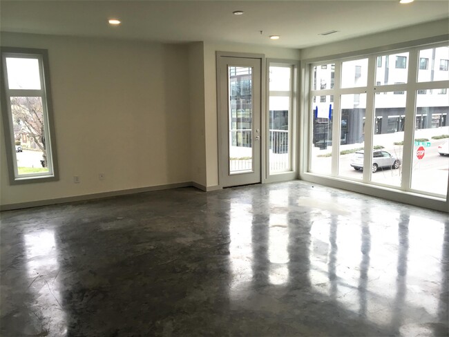 Living room with floor to ceiling windows and concrete floors - 701 Cleo Miller Dr