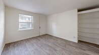 Located at 2265 Perry Blvd NW in Atlanta, Georgia, this two-bedroom, one-bathroom residence offers a clean, move-in-ready layout across a single floor. Light-toned luxury vinyl plank flooring runs continuously throughout the unit, lending a cohesive and modern feel to every room. The open living area provides a comfortable gathering space, flowing naturally into the combined dining room and kitchen. The galley-style kitchen is efficiently designed, featuring gray cabinetry, a stainless steel refrigerator, electric range, and dishwasher, with a rear door that brings in natural light. A connecting hallway links the main living areas to the two bedrooms, each finished with the same warm flooring and crisp white walls. The primary bedroom is generously sized with its own closet, while the second bedroom also includes a closet and a window that brightens the space. Both bedrooms are well-proportioned and offer a calm, neutral backdrop. The full bathroom includes a tiled tub-shower combination with a window above for natural ventilation. Two dedicated closets provide practical storage throughout the unit. The overall aesthetic is clean and understated, making it a functional and comfortable home in northwest Atlanta.