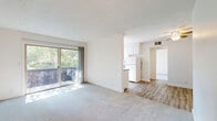 Located at 3535 Marconi Ave. in Sacramento, CA, this one-bedroom, one-bathroom unit offers a thoughtfully laid-out single-floor plan. The open living area is bright and welcoming, featuring plush carpet flooring and a sliding glass door that leads to a private balcony overlooking lush greenery — filling the space with natural light. The layout flows seamlessly into a combined dining area and galley-style kitchen, which is equipped with white cabinetry, a full-size refrigerator, an electric range, and a dedicated window that brings in additional natural light. Hardwood-style flooring carries through the kitchen and hallway, adding warmth and contrast to the neutral palette throughout. The bedroom is a comfortable, carpeted retreat with its own sliding glass door to a balcony, a window with outdoor views, and access to two closets for ample storage. A ceiling fan adds to the room's comfort. The hallway connects the living areas to the full bathroom, which features a tub-shower combination with brushed nickel fixtures. Clean white walls, textured ceilings, and a consistent neutral color scheme give the entire unit a bright, cohesive feel.