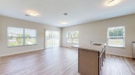 This well-appointed single-floor residence offers a clean, modern aesthetic throughout its thoughtfully designed layout. The open-concept living and dining area is anchored by smooth wood-look luxury vinyl flooring that flows seamlessly from the kitchen peninsula into the expansive living space. Large sliding glass doors lead to a private balcony, while multiple windows flood the interior with abundant natural light and offer pleasant outdoor views, creating an airy and welcoming atmosphere.

The kitchen is equipped with stainless steel appliances, including a refrigerator, range, and microwave, complemented by taupe cabinetry that extends to the ceiling for generous storage. Light granite countertops continue onto the kitchen island, which also features a sink — ideal for both meal prep and casual dining.

The bedrooms provide a comfortable retreat, finished with plush wall-to-wall carpeting and windows that bring in natural light. Each room offers a calm, neutral palette with ample space.

The bathrooms are finished with the same granite countertops found in the kitchen, paired with light wood cabinetry, undermount sinks, large mirrors, and wood-look flooring. Walk-in showers provide a clean, functional design. Overall, the residence presents a cohesive, contemporary style throughout.