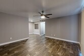 Located in Phoenix, AZ, this 2-bedroom, 3-bathroom single-floor home offers a thoughtfully designed layout with a cohesive, modern aesthetic throughout. The open living area makes a strong first impression with rich wood-look flooring, neutral gray walls, and a ceiling fan with integrated lighting. Built-in shelving adds both character and practical storage, while vertical blinds allow natural light to filter through to the space. The kitchen is well-equipped, featuring crisp white shaker-style cabinetry, granite-look countertops, a double stainless steel sink with a gooseneck faucet, and a window that brings in additional natural light. Stainless steel appliances complete the functional and stylish cooking space. The bedrooms offer a comfortable retreat, with plush carpet flooring, neutral wall tones, and closet access. The primary bedroom is a generous size, providing ample room for furnishings. Three bathrooms serve the home, each finished with granite-topped vanities, white cabinetry, and tub-shower combinations with clean, bright surrounds. The consistent use of wood-look flooring in wet areas and carpet in bedrooms creates a well-balanced and practical interior throughout this efficiently designed Phoenix home.
