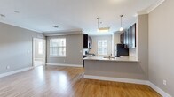 Located at 111 Holling Dr in Frederick, Maryland, this well-appointed 2-bedroom, 3-bathroom residence offers a thoughtfully designed single-level layout. The open-concept living and kitchen area serves as the heart of the home, bathed in natural light from multiple windows dressed with classic plantation shutters. Crown molding adds a refined architectural touch throughout the main living spaces, which feature warm hardwood-style flooring.

The kitchen is a standout, showcasing rich dark-espresso cabinetry, granite countertops, a classic subway tile backsplash, and stainless steel appliances. A peninsula with pendant lighting provides additional counter space and casual seating, seamlessly connecting the kitchen to the living area.

Both bedrooms are generously proportioned, with plush carpeting and large windows that invite natural light. The primary bedroom includes a ceiling fan and direct access to an en-suite bathroom. The bathrooms are finished with tile flooring, dark wood vanities, and brushed nickel fixtures, with one featuring a full tub-shower combination.

A connecting hallway ties the rooms together with practicality and flow. The neutral warm-gray palette throughout creates a cohesive, calm ambiance, making this a comfortable and move-in-ready residence in Frederick, MD.