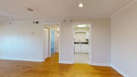 Located at 525 N Dupont Ave in Nashville, Tennessee, this one-bedroom, one-bathroom residence offers a well-organized single-floor layout with a thoughtful mix of finishes throughout. The living room is a bright, open space featuring warm hardwood floors, crown molding, recessed lighting, and a set of French doors that invite natural light and provide access to an outdoor balcony. A connecting hallway leads to the remaining rooms, maintaining a practical and efficient flow. The kitchen is appointed with white raised-panel cabinetry, dark countertops, a skylight overhead, tile flooring in a classic diamond pattern, and a full suite of white appliances including a range and refrigerator — all set within a compact U-shaped layout. The bedroom offers comfortable carpeted flooring, a ceiling fan with light fixture, a window for natural light, and a generous closet with bifold doors and built-in shelving. The bathroom is clean and well-maintained, featuring tile flooring, a combination shower and bathtub with a curved rod, and chrome fixtures. Crown molding is present throughout the space, adding a consistent architectural detail that ties the interiors together.