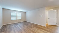 Located at 1000 Self Court in Middletown, NJ, this single-floor, four-bedroom, two-bathroom home offers a clean, modern aesthetic with a practical and well-organized layout. Luxury wood-look flooring runs throughout the living areas and bedrooms, complemented by crisp white trim and neutral wall tones that create a bright, cohesive atmosphere. The spacious living room features windows dressed with horizontal blinds, allowing natural light to fill the space. The primary bedroom is generously sized and includes a dedicated closet with built-in rod shelving, providing ample storage. The additional bedrooms are well-proportioned with the same consistent flooring and neutral palette, offering versatile spaces for a variety of uses. Two full bathrooms serve the home, each finished with light-toned tile flooring, gray vanity cabinetry, white countertops, large mirrors, and chrome fixtures. One bathroom features a walk-in shower with grab bars, while the other includes a bathtub combo. A central hallway connects the rooms efficiently. Two closets add to the home's overall storage capacity. The clean, move-in-ready condition and consistent finishes throughout make this a well-appointed residence in Middletown, New Jersey.