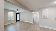 This 2-bedroom, 2-bathroom single-floor residence in Greenville, SC offers a thoughtfully designed layout with clean, modern finishes throughout. Light wood-style flooring flows consistently across the entire space, creating a cohesive and airy atmosphere. The living room serves as a welcoming entry point, featuring a ceiling fan, a bold black-framed glass door, and a window that brings in natural light and outdoor views.

The kitchen is a functional highlight, showcasing a two-tone design with white upper cabinetry and slate-blue lower cabinetry, granite-style countertops, track lighting, and a full suite of black appliances including a refrigerator, gas range, and dishwasher. An adjacent dining or flex area provides additional space for daily living.

Both bedrooms are well-proportioned, each equipped with ceiling fans. The spacious primary bedroom includes a large reach-in closet with built-in shelving and rods. The second bedroom offers natural light via a window with blinds. The two bathrooms maintain the same neutral color palette, with the full bath featuring a soaking tub and recessed lighting.

A dedicated in-unit laundry room accommodates a full-size GE washer and dryer side by side, adding everyday convenience. The overall design is clean, neutral, and move-in ready.