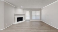 Located at 4753 Old Bent Tree Lane in Dallas, TX, this well-appointed 1-bedroom, 2-bathroom residence offers a thoughtfully designed single-level layout. The open-concept living area is a standout, featuring light wood-style flooring, crown molding, a textured ceiling, and a corner fireplace framed in crisp white — creating a clean, modern focal point. Multiple windows dressed with white blinds allow natural light to fill the space, while a door provides direct outdoor access.

The kitchen is efficiently laid out with white cabinetry accented by matte black hardware, quartz countertops, a peninsula with an undermount sink, and stainless steel appliances including a refrigerator, range, microwave, and dishwasher. A skylight above adds a bright, airy quality to the cooking space.

The bedroom is generously sized for the layout, equipped with a ceiling fan, wood-style flooring, and a dedicated closet. Both bathrooms are finished in a neutral palette; one features a wide vanity with quartz countertops and black fixtures, while the other includes a full tub-shower combination with white tile surround and matte black hardware. The hallway connects all areas cohesively, completing this clean, move-in-ready home.
