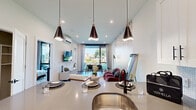 Located at 377 Crane St in Orange, NJ, this single-floor residence offers a thoughtfully designed open-concept layout with contemporary finishes and abundant natural light throughout. The kitchen serves as a central hub, featuring white shaker cabinetry, a subway tile backsplash, stainless steel appliances, and a large island with quartz countertops and pendant lighting — ideal for both cooking and casual dining. The living and dining area flows seamlessly from the kitchen, highlighted by a striking mosaic accent wall, large floor-to-ceiling windows, and direct access to an outdoor patio, flooding the space with natural light and outdoor views. A wall-mounted mini-split system ensures year-round comfort. The bedroom is a serene retreat, distinguished by a bold terracotta accent wall, large black-framed windows, and sliding glass door access to a private balcony. A generously sized walk-in closet with dual hanging rods and overhead shelving provides ample storage. The bathroom is finished with large-format dark tile in the shower/tub surround, black matte fixtures, a white vanity with a grey countertop, and built-in open shelving. Wood-look flooring runs consistently throughout, tying the modern aesthetic together cohesively.