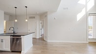 Located at 1500 Bell Rd in Nashville, TN, this two-story home offers a thoughtfully designed layout spread across two floors. The main level features an open-concept living and kitchen area highlighted by dramatically soaring ceilings that amplify the sense of space. The kitchen is a standout, boasting white shaker cabinetry, dark granite countertops, stainless steel appliances, and a large central island with a matte black faucet, all accented by sleek pendant lighting. Light wood-look flooring flows throughout the main level, complementing the clean, neutral palette. The living area is flooded with natural light through tall windows and features a glass-panel door that opens to an outdoor balcony area with views of the surrounding greenery. The home includes four bedrooms, with the primary suite offering a spacious walk-in closet and a refined en-suite bathroom featuring a double-sink vanity with dark granite counters, white cabinetry with matte black hardware, large-format tile flooring, and a glass-enclosed shower. Additional bedrooms are carpeted for comfort, and secondary bathrooms maintain a consistent clean, modern aesthetic with tile flooring and pedestal or vanity sinks. Two closets and two hallways further enhance the functional flow of this well-appointed Nashville home.