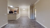 Located at 526 Dill Ln in Murfreesboro, Tennessee, this single-floor residence offers a well-organized layout with consistent, modern finishes throughout. The living area is spacious and inviting, featuring durable wood-look plank flooring, crown molding, and a ceiling fan — details that contribute to a clean, polished aesthetic. A glass door connects the living space to the outdoors, allowing natural light to flow in.

The kitchen is outfitted with warm medium-tone wood cabinetry, granite-style countertops, and black appliances including an electric range, built-in microwave, and dishwasher. A breakfast bar provides a convenient transition between the kitchen and the adjacent dining area, which is accented by a chandelier overhead and crown molding.

The bedrooms feature the same wood-look flooring and neutral wall tones, with windows fitted with blinds for natural light and privacy. The bathrooms include vanities with matching granite-style countertops and wood cabinetry, a tub-shower combination, and wood-look tile flooring. One bathroom offers a soaking tub with a tiled surround.

A dedicated laundry room includes wire shelving, full washer and dryer hookups, and a ventilation connection. The home's cohesive neutral color palette and consistent flooring create a unified, functional living environment throughout.