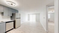 Located at 12131 W 57th Dr in Arvada, Colorado, this efficiently designed one-bedroom, two-bathroom residence offers a clean, modern aesthetic throughout its single-floor layout. Light wood-style flooring flows continuously across all rooms, complementing the crisp white walls and bright, airy atmosphere that defines the space.

The open living area is a standout feature, bathed in natural light streaming through a large sliding glass door dressed with vertical blinds. Recessed lighting and baseboard heating add both function and comfort to the room.

The kitchen is well-appointed with slate-gray cabinetry, light granite-style countertops, a white subway tile backsplash, and a full suite of stainless steel appliances including a refrigerator, range, over-the-range microwave, and dishwasher. A modern flush-mount light fixture with a circular design adds a contemporary touch overhead.

The bedroom is a comfortable, well-proportioned retreat with a dedicated ceiling fan/light fixture, a window for natural light, and a wall-mounted HVAC unit alongside baseboard heating for year-round climate control. Two closets provide practical storage throughout the unit.

The two bathrooms maintain the home's clean design language, with one featuring a soaking tub surrounded by large-format white tile. The overall ambiance is modern, minimal, and move-in ready.