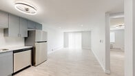 Located at 12131 W 57th Dr in Arvada, Colorado, this efficiently designed one-bedroom, two-bathroom residence offers a clean, modern aesthetic throughout its single-floor layout. Light wood-style flooring flows continuously across all rooms, complementing the crisp white walls and bright, airy atmosphere that defines the space.

The open living area is a standout feature, bathed in natural light streaming through a large sliding glass door dressed with vertical blinds. Recessed lighting and baseboard heating add both function and comfort to the room.

The kitchen is well-appointed with slate-gray cabinetry, light granite-style countertops, a white subway tile backsplash, and a full suite of stainless steel appliances including a refrigerator, range, over-the-range microwave, and dishwasher. A modern flush-mount light fixture with a circular design adds a contemporary touch overhead.

The bedroom is a comfortable, well-proportioned retreat with a dedicated ceiling fan/light fixture, a window for natural light, and a wall-mounted HVAC unit alongside baseboard heating for year-round climate control. Two closets provide practical storage throughout the unit.

The two bathrooms maintain the home's clean design language, with one featuring a soaking tub surrounded by large-format white tile. The overall ambiance is modern, minimal, and move-in ready.