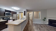 Located at 142 BPW Club Rd in Chapel Hill, NC, this single-story unit offers a practical and well-appointed layout with a neutral color palette throughout. The galley-style kitchen is a standout feature, equipped with dark espresso cabinetry, stainless steel appliances including a refrigerator, range, and over-the-range microwave, granite-style countertops, and wood-look flooring. A peninsula with a built-in sink connects the kitchen to the main living area, creating an open, functional flow between spaces.

The living and dining areas transition seamlessly from the kitchen, with wood-look flooring giving way to plush carpeting in the bedroom areas. The bedrooms are generously proportioned, featuring neutral gray walls, textured ceilings, and windows that allow natural light to fill the space. Each room offers a calm, understated atmosphere.

The bathroom is well-designed with a granite-style vanity countertop, dark cabinetry, a large framed mirror with overhead lighting, and wood-look flooring. A dedicated laundry area houses a full-size side-by-side washer and dryer, adding everyday convenience. Overall, the unit delivers a clean, modern aesthetic with practical amenities throughout.