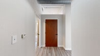 Located in Kansas City, MO, this 2-bedroom, 2-bathroom loft-style residence offers an impressive blend of industrial character and contemporary comfort. The open living area makes an immediate statement with light hardwood-style flooring, soaring ceilings, exposed galvanized ductwork, and a row of large windows that flood the space with natural light and frame views of the surrounding urban streetscape.

The kitchen is well-appointed with warm-toned cabinetry, light quartz countertops, a central island with a built-in cooktop, stainless steel appliances including a refrigerator and dishwasher, and a black matte sink fixture — a functional and stylish hub for cooking and entertaining.

Both bedrooms are carpeted and generously sized, each featuring ceiling fans and closets. The primary bedroom includes an en-suite bathroom and additional closet space, while the secondary bedroom benefits from dual windows overlooking neighboring architecture. Exposed ductwork continues into the bedrooms, reinforcing the loft aesthetic throughout.

The two bathrooms are clean and functional. One features wood-toned cabinetry with a white countertop and luxury vinyl plank flooring, while the second includes a tub-shower combo and built-in shelving in the adjoining closet. Two hallways connect the spaces efficiently, and the overall layout offers a practical, comfortable flow throughout.