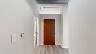 Located in Kansas City, MO, this 2-bedroom, 2-bathroom loft-style residence offers an impressive blend of industrial character and contemporary comfort. The open living area makes an immediate statement with light hardwood-style flooring, soaring ceilings, exposed galvanized ductwork, and a row of large windows that flood the space with natural light and frame views of the surrounding urban streetscape.

The kitchen is well-appointed with warm-toned cabinetry, light quartz countertops, a central island with a built-in cooktop, stainless steel appliances including a refrigerator and dishwasher, and a black matte sink fixture — a functional and stylish hub for cooking and entertaining.

Both bedrooms are carpeted and generously sized, each featuring ceiling fans and closets. The primary bedroom includes an en-suite bathroom and additional closet space, while the secondary bedroom benefits from dual windows overlooking neighboring architecture. Exposed ductwork continues into the bedrooms, reinforcing the loft aesthetic throughout.

The two bathrooms are clean and functional. One features wood-toned cabinetry with a white countertop and luxury vinyl plank flooring, while the second includes a tub-shower combo and built-in shelving in the adjoining closet. Two hallways connect the spaces efficiently, and the overall layout offers a practical, comfortable flow throughout.