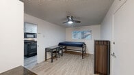 Located at 1863 Kincaid St in Eugene, Oregon, this single-floor, one-bedroom, two-bathroom unit offers a thoughtfully arranged layout that maximizes every square foot. Light wood-style flooring runs throughout the space, lending a clean and cohesive look across all rooms.

The bedroom is a well-proportioned private retreat, outfitted with a ceiling fan with integrated lighting and a window that allows natural light to filter in. A closet provides convenient storage, and the room connects easily to the rest of the unit.

The kitchen is efficiently designed with white cabinetry, dark granite-style countertops, and black appliances including a range, over-the-range microwave, and dishwasher. A window above the sink brings in additional light. Adjacent to the kitchen is a combined living and dining area, offering flexible space for daily living with room for a dining table and seating.

Two full bathrooms serve the unit, one featuring a tub-shower combination with white subway tile surround and a window for natural ventilation. The textured ceilings are consistent throughout, adding a classic residential character.

This unit presents a practical and well-maintained living space well-suited for individuals seeking functional, no-frills accommodations in Eugene.